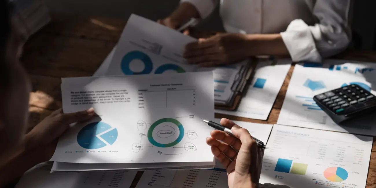 Business People Meeting using laptop computer,calculator,notebook,stock market chart paper for analysis Plans to improve quality next month. Conference Discussion Corporate Concept.